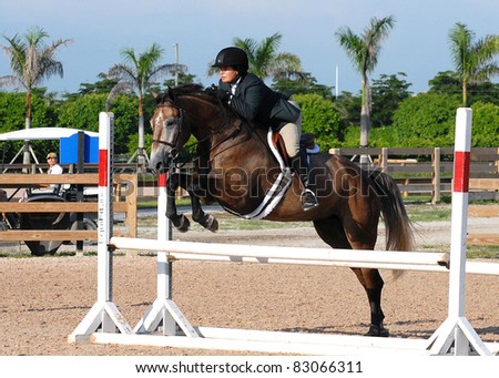 WELLINGTON, FLORIDA - AUGUST 13: An unidentified rider takes a fence at the South Florida Hunter Jumper Association's Summer Series on August 13, 2011 in Wellington, Florida.