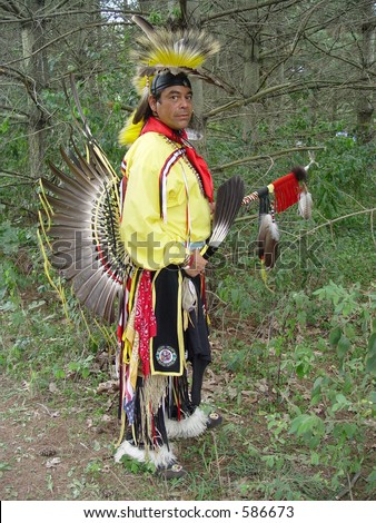 Native American man holding eagle feathers.