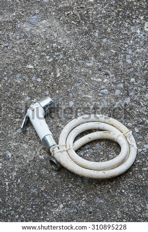 Faucet with a hose, white, old place on the old concrete floor also available .