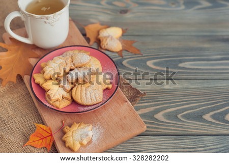 Delicious homemade cookies in the form of a maple leaf, oak leaves and acorns on wooden background.