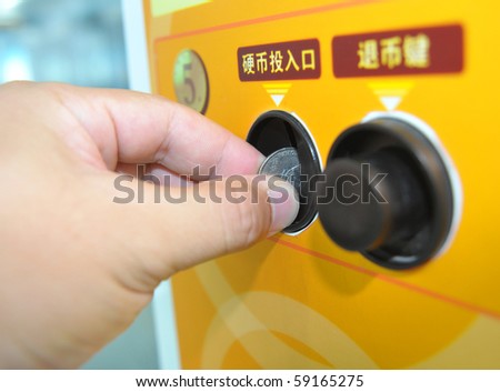 Close-up Hand holding a coin input self service machine