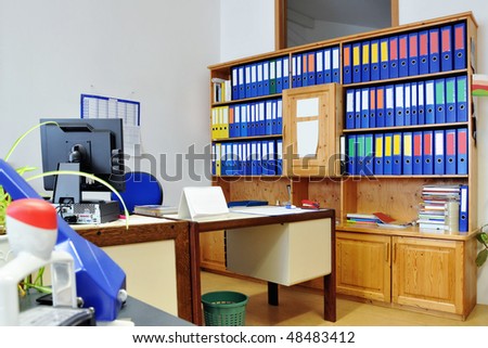 An Office. Cupboard with a few of files. Desk with a personal computer
