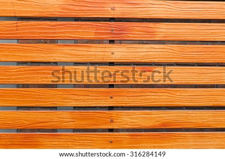 horizontal orange wooden fence close up