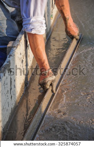 plasterer concrete cement worker plastering flooring of house construction evening of Thailand