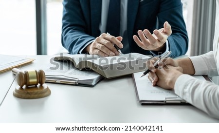 Male lawyer is pointing on legal document to explaining about consultation terms and condition to businesswoman before signing on contract at law firm. Foto d'archivio © 