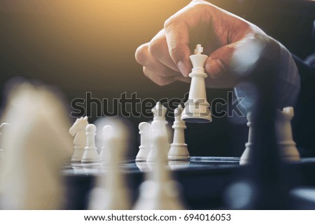 Similar – Image, Stock Photo Player moves a chess piece on a chessboard