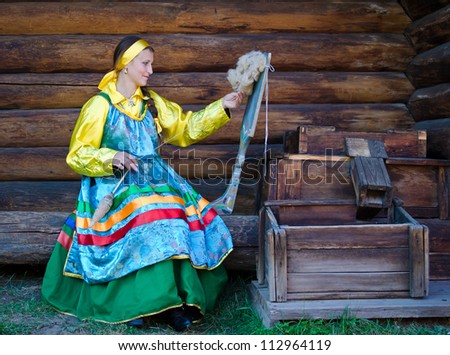 ULAN-UDE, RUSSIA - SEPTEMBER 13:  Unidentified women in traditional Russian dress spinning yarn. Costume show at Baikal Economic Forum, September 13, 2012 in Ulan-Ude, Buryatia, Russia