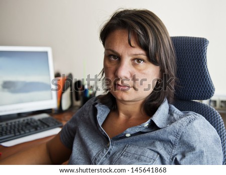 Woman office worker at her workplace. Real people series.
