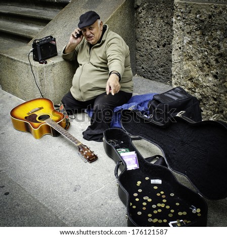 MILAN, ITALY - MAY 04, 2012: Elderly beggar musician with guitar ask for money on street of Milan/
