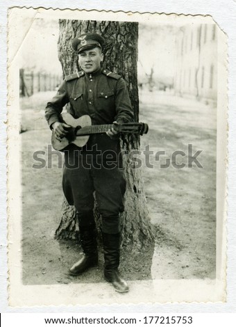 KURSK, USSR - CIRCA 1960s: An antique photo shows portrait of a Red Army soldiers with a guitar in his hands.