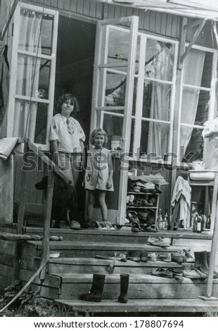 MOSCOW, USSR - CIRCA 1970s : An antique photo shows two little girls on the threshold of a country house. \