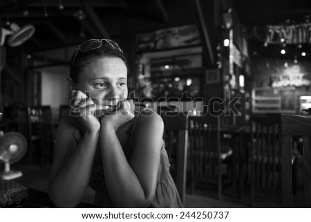 Black and white portrait of an adult woman alone in a cafe