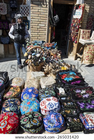 BUKHARA, UZBEKISTAN - MARCH 16, 2015: Gift shop. Giirl sells national headgear - the skullcap.