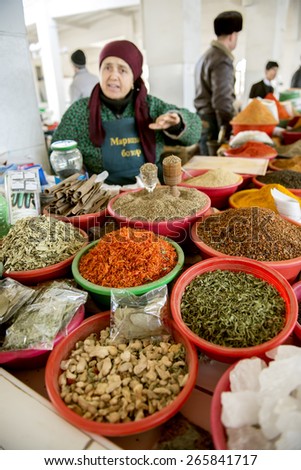 BUKHARA, UZBEKISTAN - MARCH 16, 2015: City grocery market. Woman sells nuts and dried fruits.