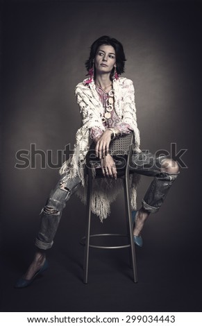 Studio portrait of young woman sitting on a chair.