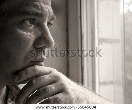 Sad man looking out the window