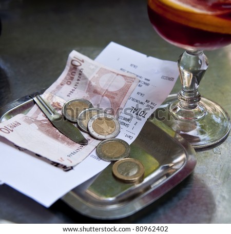 Restaurant bill and money on matal tray