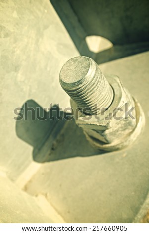 Close up of a larger screw into the base of a metal pillar.