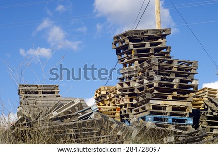 Wood pallets stacked with blue sky.