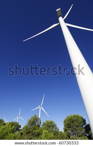 group of wind turbines in a wooded area
