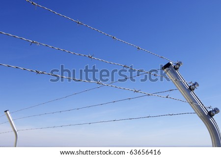 foreground of a barbed wire fence on a clear day