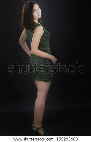 Beautiful woman model posing in elegant dress isolated on black background. Fashion Photo.