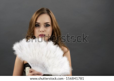 The young woman with a fan from gray  feathers