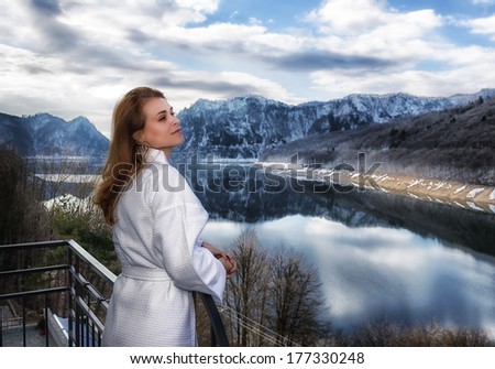 woman relaxes by looking at a mountain landscape