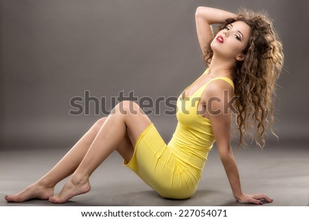 Female fashion model  yellow dress against gray background