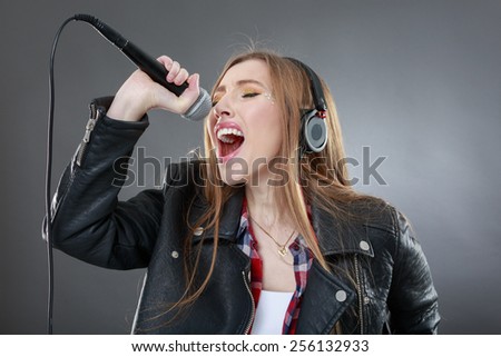 woman with headphones and microphone singing