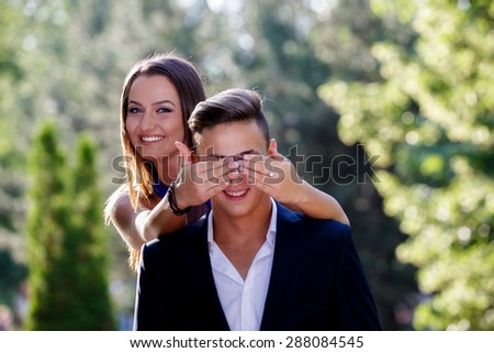 Photo of a woman covering the eyes of a man