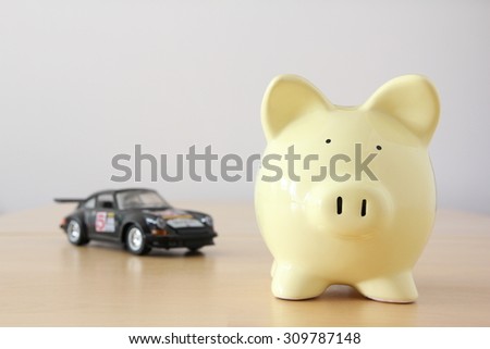 Yellow piggy bank on bright background, savings on car.
