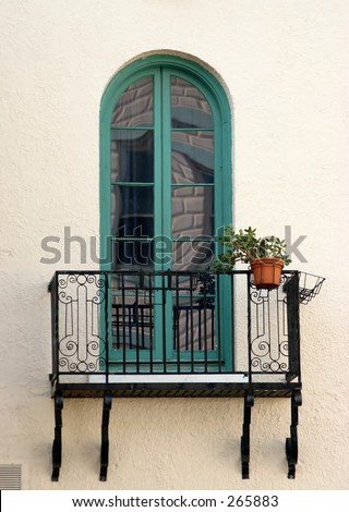 window with green trim and wrought iron railing on patio