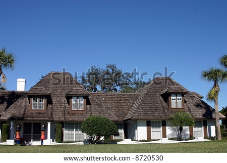upper class home with brown shaker shingles