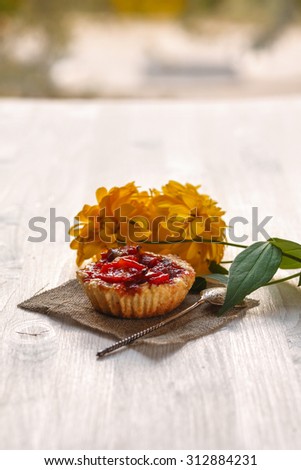 Tart apples on linen textiles on a white wooden table decorated yellow flowers, textile and spoon.