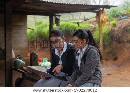 Girls students doing their homework with a digital tablet at home.