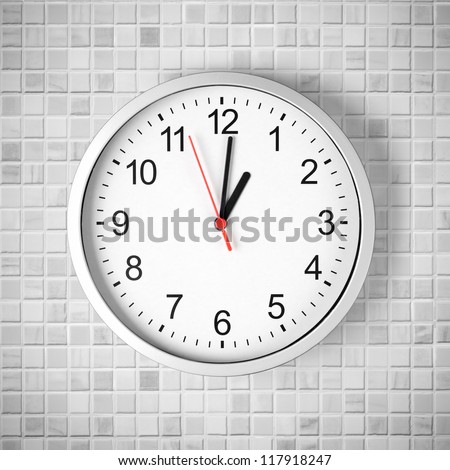 Simple clock or watch on white tile wall displaying one o\'clock