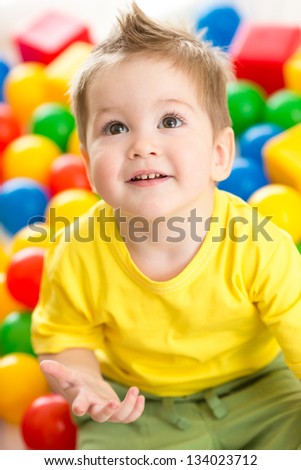 Cute kid or child playing colorful balls top view