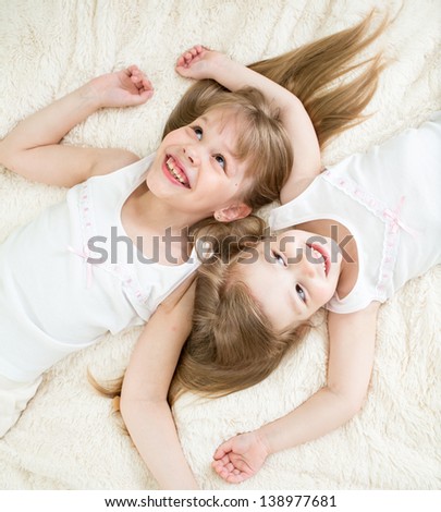 happy kids lying on back in pajamas top view
