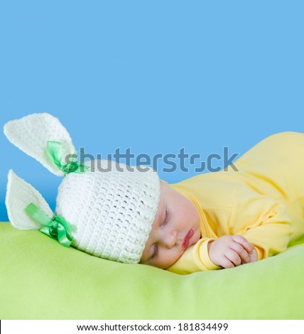 sleeping baby closeup portrait in hare or rabbit hat with expandable blue copyspace
