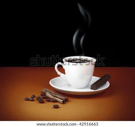 Black coffee cup with steam and piece of chocolate, beans and cinnamon