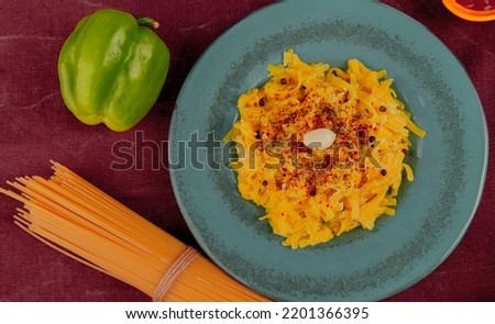 top view of macaroni pasta in plate with pepper and vermicelli on bordo cloth background Stok fotoğraf © 