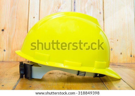 Engineer or Worker Yellow Safety Helmet Hat with SAFETY FIRST word tag on Wood background