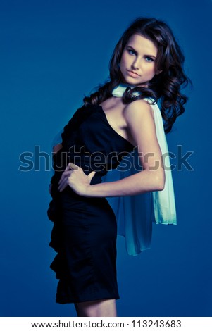 Blue fashion - beautiful young girl in blue dress over blue background