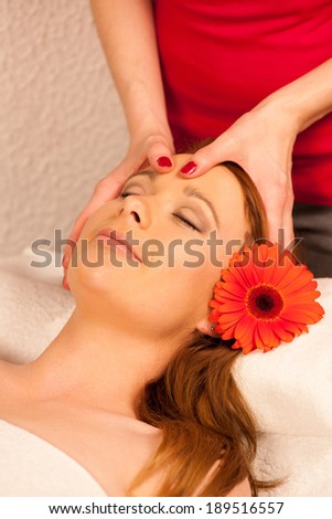 Woman having face massage treatment in wellness center