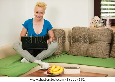 Young woman  with laptop on the couch in living room