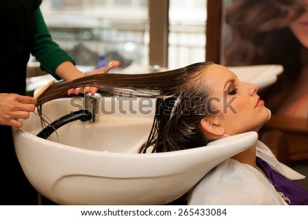 Hairdresser making hair treatment to a customer in salon