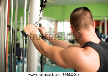 Young athletic man works out in fitness - gym workout