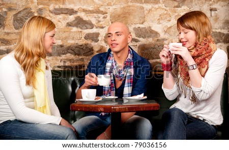 Three friends in cafe discussing and having fun