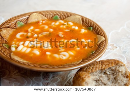 Nourishing soup with meat and pasta. With  bread on the table
